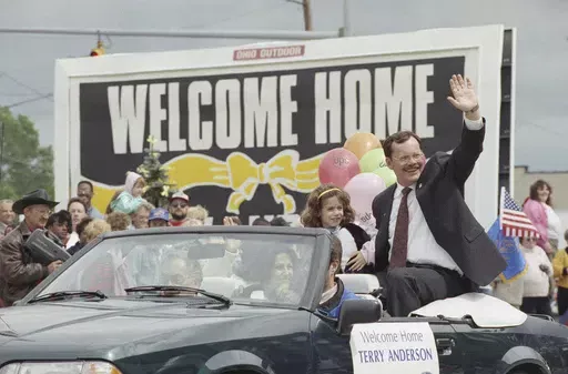 Former hostage Terry Anderson waves to the crowd as he rides in a parade in Lorain, Ohio, June 22, 1992. Anderson, the globe-trotting Associated Press correspondent who became one of America’s longest-held hostages after he was snatched from a street in war-torn Lebanon in 1985 and held for nearly seven years, died Sunday, April 21, 2024. He was 76. (AP Photo/Mark Duncan, File)