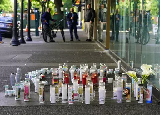 Candles and flowers make up a memorial, Tuesday, April 5,2022, at a memorial for those killed and injured in a mass shooting on April 3, 2022, in Sacramento, Calif. Dandrae Martin, who is facing charges connected to Sundays mass shooting, made his first court appearance in Sacramento County Superior Court, Tuesday. Martin, 26, was arrested as a "related suspect," on charges of assault with deadly weapon and being a convict carrying a loaded gun. (AP Photo/Rich Pedroncelli)