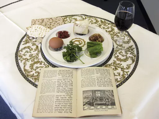 A 1936 Maxwell House Haggadah sits on a desk alongside a Seder plate on March 15, 2011, in New York. (AP Photo/Stace Maude, File)