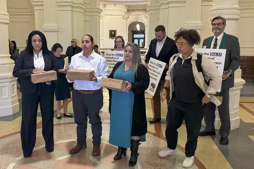 Casandra Rivera, left, Anna Vasquez, second from left, and Elizabeth Ramirez, center, of the "San Antonio 4" group, hold boxes with petitions being delivered in the Texas State capitol for Texas Gov. Greg Abbott seeking the pardoning of Robert Roberson's execution, Wednesday, Oct. 16, 2024 in Austin, Texas. Roberson, 57, is scheduled to receive a lethal injection on Oct. 17, for the 2002 killing of his 2-year-old daughter, Nikki Curtis, in the East Texas city of Palestine. Roberson has long proc