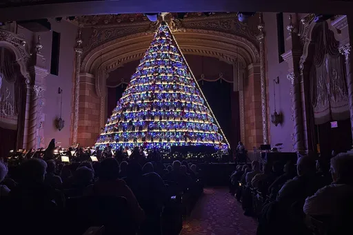 High school students sing while standing in a 67-foot-tall structure as part of the annual Mona Shores Singing Christmas Tree show Tuesday, Dec. 3, 2024, in Muskegon, Mich. (AP Photo/Mike Householder)