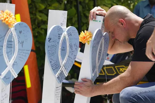 Lazaro Carnero mourns for his best friend Edgar Gonzalez, during a remembrance event at the site of the Champlain Towers South building collapse, Friday, June 24, 2022, in Surfside, Fla. Friday marks the anniversary of the oceanfront condo building collapse that killed 98 people in Surfside, Florida. The 12-story tower came down with a thunderous roar and left a giant pile of rubble in one of the deadliest collapses in U.S. history. (AP Photo/Wilfredo Lee)