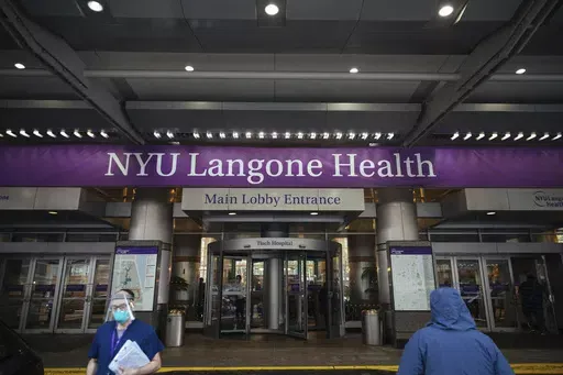 Health care workers walk in and out of the entrance at NYU-Langone Hospital on Monday, Dec. 14, 2020, in New York. A nurse was fired by the hospital after she referred to Israel's war in Gaza as "genocide" during a speech accepting an award. Labor and delivery nurse Hesen Jabr, who is Palestinian American, was being honored by NYU Langone Health for her compassion in caring for mothers who had lost babies when she drew a link between her work and the suffering of mothers in Gaza. (AP Photo/Kevin