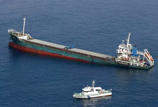 This aerial photo shows Belize-registered cargo ship Xin Hai 99, after a collision, off Kushimoto, Wakayama prefecture, southwestern Japan, Saturday, Aug. 20, 2022. A Japanese chemical tanker ship crashed into the cargo ship off the coast of southwestern Japan, the coast guard said Saturday.(Kyodo News via AP)
