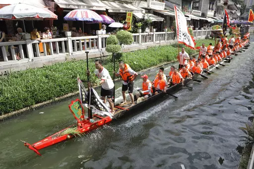 Dragon boat participants from Panting village row along a canal in the historic Lychee Bay scenic area in Guangzhou in southern China's Guangdong Province, Friday, June 3, 2022. Dragon boat races returned in parts of China on Friday for the first time since the outbreak of the pandemic in late 2019, as restrictions are lifted along with a major drop in COVID-19 cases. (AP Photo/Caroline Chen)