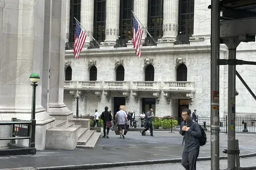 People pass the New York Stock Exchange, at rear, on Aug. 27, 2024, in New York. (AP Photo/Peter Morgan, File)