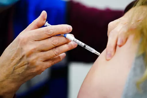 A health worker administers a dose of a COVID-19 vaccine during a vaccination clinic at the Keystone First Wellness Center in Chester, Pa., on Dec. 15, 2021. Government advisers are debating Tuesday, June 28, 2022, if Americans should get a modified COVID-19 booster shot this fall — one that better matches more recent virus variants. (AP Photo/Matt Rourke, File)