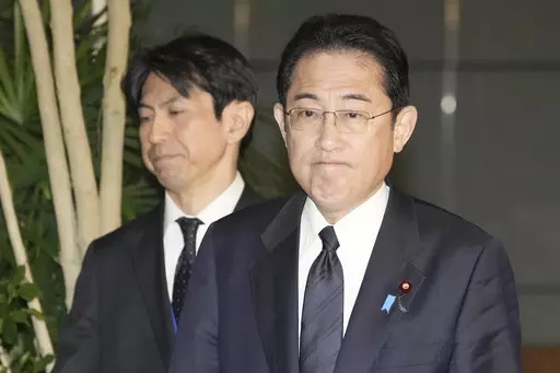 Japan's Prime Minister Fumio Kishida, right, meets reporters after an army helicopter went missing, at his official residence in Tokyo Thursday, April 6, 2023. Japan's coast guard says it is searching for an army helicopter carrying 10 crew members that went missing off a southern Japanese island. Kishida said the Defense Ministry is investigating and "We will do our utmost to save their lives." (Kyodo News via AP)