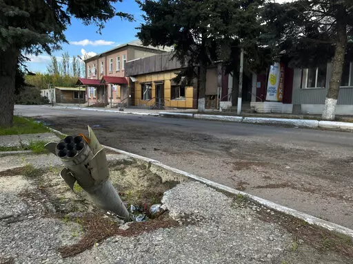 A part of a rocket sits wedged in the ground on a street in the recaptured town of Lyman, Ukraine, Friday, Oct. 7, 2022. Ukrainian authorities are just beginning to sift through the wreckage of the devastated city of Lyman in eastern Ukraine as they assess the humanitarian toll, and possibility of war crimes, from a months-long Russian occupation. (AP Photo/Justin Spike)