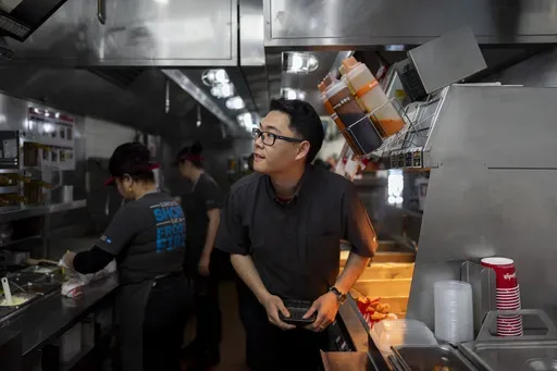Lawrence Cheng, whose family owns seven Wendy's locations south of Los Angeles, works in the kitchen at his Wendy's restaurant in Fountain Valley, Calif., June 20, 2024. Cheng used to have nearly a dozen employees at his Fountain Valley location during the day. Now, he only schedules seven for each shift as he scrambles to absorb a dramatic jump in labor costs after a new California law boosted the hourly wage for fast food workers on April 1 from $16 to $20 an hour. (AP Photo/Jae C. Hong)