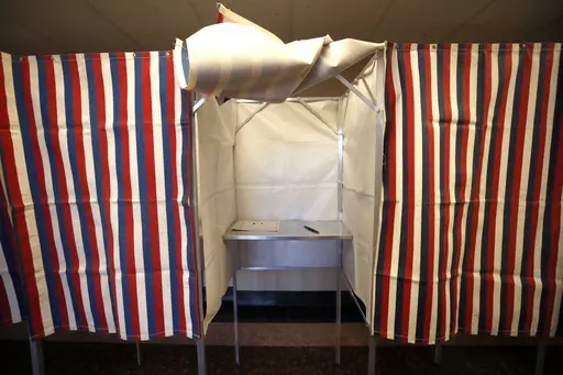 A booth is ready for a voter, Feb. 24, 2020, at City Hall in Cambridge, Mass., on the first morning of early voting in the state. Thanks to recent advances in artificial intelligence, tools that can create lifelike photos, video and audio are now cheap and readily available. AI experts and political scientists say these new programs will have significant implications for next year's U.S. elections. (AP Photo/Elise Amendola, File)