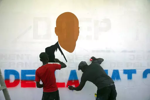 Artists paint a portrait of slain Haitian President Jovenel Moise near the presidencial residence where he was assassinated in the Petion-ville area of Port-au-Prince, Haiti, Thursday, July 7, 2022. A year has passed since Moise was assassinated at his private home. (AP Photo/Odelyn Joseph)
