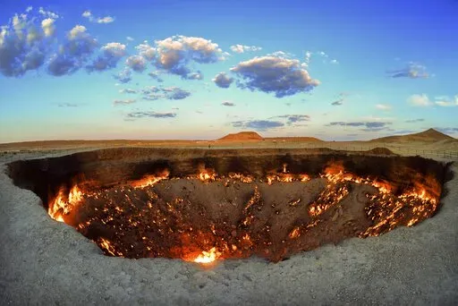 The crater fire named "Gates of Hell" is seen near Darvaza, Turkmenistan, Saturday, July 11, 2020. The president of Turkmenistan is calling for an end to one of the country's most notable but infernal sights — the blazing desert natural gas crater widely referred to as the “Gates of Hell.” The crater, about 260 kilometers (160 miles) north of the capital Ashgabat, has been on fire for decades and is a popular sight for the small number of tourists who come to Turkmenistan, which is difficu