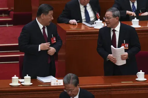 Chinese Premier Li Qiang, right, chats with Chinese President Xi Jinping after the opening session of the National People's Congress (NPC) at the Great Hall of the People in Beijing, China, Wednesday, March 5, 2025. (AP Photo/Ng Han Guan)