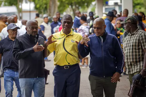 African National Congress (ANC) treasurer general Paul Mashatile, center, walks out following a meeting of the ANC's national executive committee in Johannesburg, South Africa, Friday Dec. 2, 2022. South Africa's president Cyril Ramaphosa, who did not attend the meeting, might lose his job, and his reputation as a corruption fighter, as he faces possible impeachment over claims that he tried to cover up the theft of millions of dollars stashed inside a couch on his farm. (AP Photo/Jerome Delay)