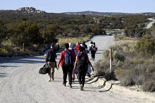 Asylum-seekers walk to a U.S. Border Patrol van after crossing the nearby border with Mexico, Tuesday Sept. 26, 2023, near Jacumba Hot Springs, Calif. Migrants continue to arrive to desert campsites along California's border with Mexico, as they await processing. Congress is discussing changes to the immigration system in exchange for providing money to Ukraine in its fight against Russia and Israel for the war with Hamas. (AP Photo/Denis Poroy, File)