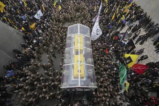 A trailer carrying the coffins containing the bodies of Hezbollah's former leader Hassan Nasrallah and his cousin and successor Hashem Safieddine drives through the crowd during a funeral procession at the Sports City Stadium in Beirut, Lebanon, Sunday, Feb. 23, 2025. (AP Photo/Hassan Ammar)