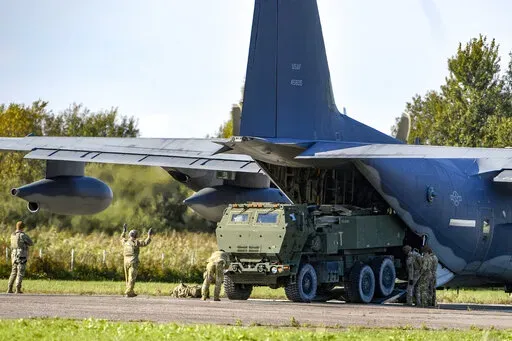Soldiers load a High-Mobility Artillery Rocket System (HIMARS ) from a US Special Operations MC-130J aircraft during military exercises at Spilve Airport in Riga, Latvia, on Sept. 26, 2022. A series of embarrassing military losses for Moscow in recent weeks has presented a growing challenge for prominent hosts of Russian news and political talk shows scrambling to find ways to paint Kyiv's gains in a way that is still favorable to the Kremlin. (AP Photo/Roman Koksarov, File)