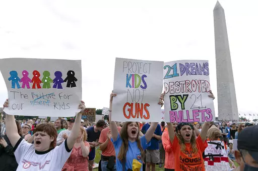 People hold signs in the second March for Our Lives rally in support of gun control in front of the Washington Monument, Saturday, June 11, 2022, in Washington. The rally is a successor to the 2018 march organized by student protestors after the mass shooting at a high school in Parkland, Fla. (AP Photo/Jose Luis Magana)