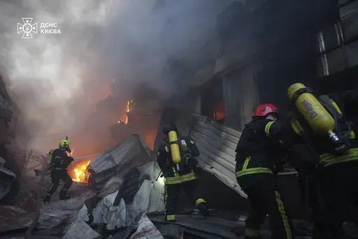 In this photo provided by the Ukrainian Emergency Service, emergency services personnel work to extinguish a fire following a Russian missile attack in Kyiv, Ukraine, Sunday, April 6, 2025. (Ukrainian Emergency Service via AP)