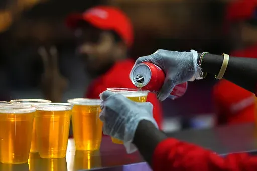 Staff member pours a beer at a fan zone ahead of the FIFA World Cup, in Doha, Qatar Saturday, Nov. 19, 2022. The last-minute decision to ban the sale of beer at World Cup stadiums in Qatar is the latest example of some the tensions that have played out ahead of the tournament. Qatari officials have for long said they were eager to welcome everybody but that visitors should also respect their culture and traditions. (AP Photo/Petr Josek)