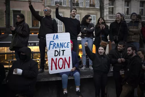 A woman holds a sign reading "France says no" during a demonstration in Marseille, southern France, Thursday, March 16, 2023. With President Emmanuel Macron thousands of miles away in China, French protesters and unions returning to the streets continue to reveal cracks in his domestic political authority. Hundreds of thousands are expected again for the 11th day of nationwide resistance to raising the retirement age from 62 to 64 Thursday, April 6 as the controversial law is being considered by