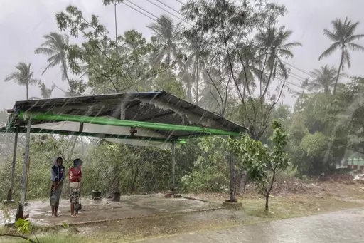 Two children stand under a roadside shelter to protect from rain before Cyclone Mocha hits in Sittwe, Rakhine State, on May 14, 2023. The United Nations has warned that far too little aid is reaching cyclone-hit areas of Myanmar and the country could face a major food crisis soon if farmers are unable to plant crops. Cyclone Mocha struck the western state of Rakhine and nearby regions last month, killing hundreds of people and damaging thousands of dwellings. (AP Photo, File)