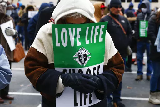 A marcher prays ahead of the North Texas March for Life, celebrating the passage and court rulings upholding the Texas law known as Senate Bill 8, on Saturday, Jan. 15, 2022, in Dallas. Abortion isn't taking center stage in Texas' first-in-the-nation primary. The March 1, 2022 primary will mark six months that Texas clinics have operated under a law that bans abortion after roughly six weeks of pregnancy.    (Shafkat Anowar/The Dallas Morning News via AP, File)