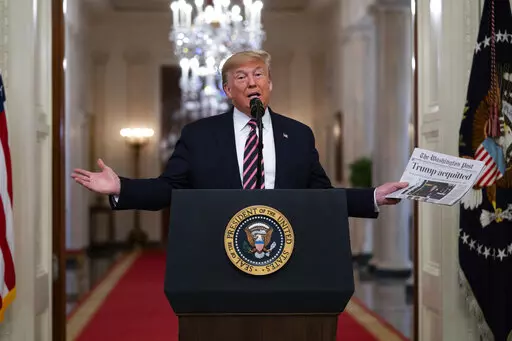 President Donald Trump holds up a newspaper with a headline that reads "Trump acquitted" during an event celebrating his impeachment acquittal, in the East Room of the White House, Feb. 6, 2020, in Washington. The impeachment investigation, sparked by a government whistleblower's complaint over Trump's call, swiftly became a milestone, the first in a generation since Democrat Bill Clinton faced charges over an affair with a White House intern. (AP Photo/Evan Vucci, File)