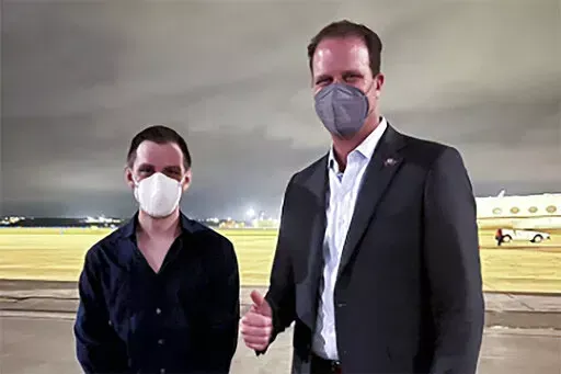 Trevor Reed, left, a Texas resident arrested in Russia in 2019, is greeted by Rep. August Pfluger, R-Texas, at a military airfield in Texas, Thursday, April 28, 2022.   (Jonathan Franks via AP)