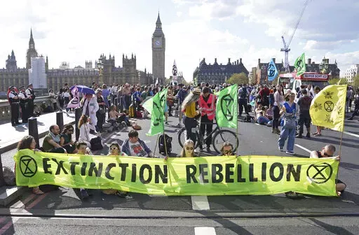 Demonstrators take part in an Extinction Rebellion protest on Westminster Bridge in London, Friday, April 15, 2022. Climate-change protesters have snarled traffic by blocking four London bridges. Cars and red double-decker buses backed up along roads as hundreds of Extinction Rebellion activists occupied London’s Waterloo, Blackfriars, Lambeth and Westminster bridges, calling for an end to new fossil fuel investments. (Stefan Rousseau/PA via AP)