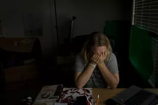 Hanna Tverdokhlib, a 37-year-old Ukrainian immigrant, breaks down in tears after talking on the phone with her friend in Ukraine Tuesday, March 1, 2022, in Long Beach, Calif. Tverdokhlib has held her phone as if it were glued to her hand since the Russian invasion of Ukraine last week. When she isn't watching news on it, she is texting her cousins and close friends back home or checking their Facebook posts, hoping her cousins are still safe in the bunker underneath their Kiev apartment building