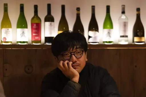 Restaurant owner Li Meng ponders before an interview at the Little Yunnan restaurant in Beijing, Wednesday, Dec. 28, 2022. After three years of quarantines pushed them close to shutting down, Li and his wife are hoping for business to rebound after China rolled back severe anti-virus controls. But now they face a new challenge: Fear of its wave of infections is keeping diners away. (AP Photo/Ng Han Guan)