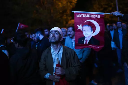 Supporters of Turkish President Recep Tayyip Erdogan watch news on a giant screen outside AKP (Justice and Development Party) headquarters in Istanbul, Turkey, Sunday, May 14, 2023. More than 64 million people, including 3.4 million overseas voters, were eligible to vote. (AP Photo/Francisco Seco)