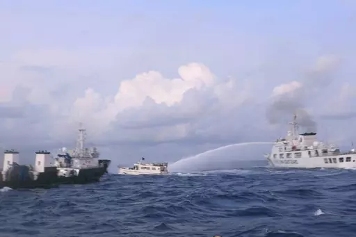 In this handout photo provided by the Philippine Coast Guard, a Chinese Coast Guard ship uses water cannons on Philippine navy-operated supply boat M/L Kalayaan as it approaches Second Thomas Shoal, locally known as Ayungin Shoal, in the disputed South China Sea on Sunday Dec. 10, 2023. The Chinese coast guard targeted Philippine vessels with water cannon blasts Sunday and rammed one of them, causing damage and endangering Filipino crew members off a disputed shoal in the South China Sea, just a