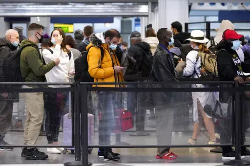 Travelers line up for flights at O'Hare International Airport in Chicago, Thursday, Dec. 30, 2021. (AP Photo/Nam Y. Huh)