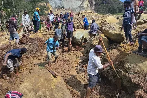 CORRECTS TO YAMBALI FOR LOCATION, NOT POGERA - Villagers search through a landslide in Yambali, in the Highlands of Papua New Guinea, Sunday, May 26, 2024. The International Organization for Migration feared Sunday the death toll from a massive landslide is much worse than what authorities initially estimated. (Mohamud Omer/International Organization for Migration via AP)
