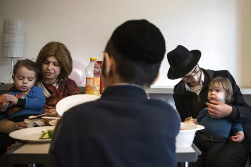 Children and their companions from an orphanage in Odesa, Ukraine, eat after their arrival at a hotel in Berlin, Friday, March 4, 2022. More than 100 Jewish refugee children who were evacuated from a foster care home in war-torn Ukraine and made their way across Europe by bus have arrived in Berlin. (AP Photo/Steffi Loos)