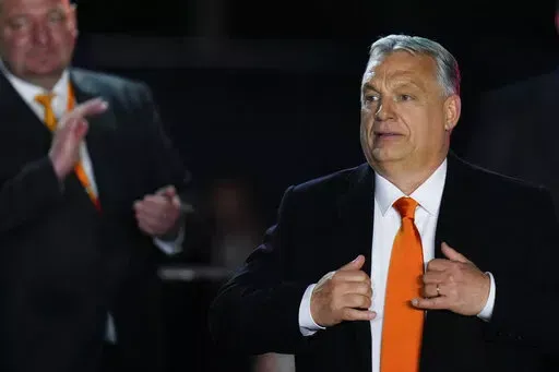 Hungary's Prime Minister Viktor Orban acknowledges cheering supporters during an election night rally in Budapest, Hungary, Sunday, April 3, 2022. Early partial results in Hungary's national election are showing a strong lead for the right-wing party of pro-Putin nationalist Orban as he seeks a fourth consecutive term. (AP Photo/Petr David Josek)