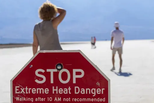 A person wipes sweat from their brow at Badwater Basin in Death Valley National Park, Calif., July 7, 2024. (AP Photo/Ty ONeil, File)