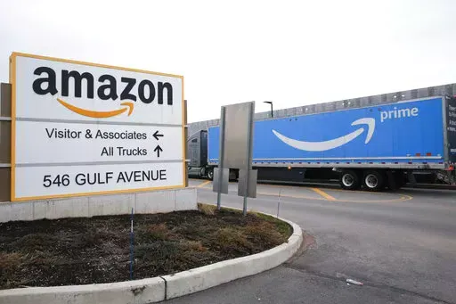 An Amazon Prime truck passes by a sign outside an Amazon fulfillment center on Staten Island, New York, on March 19, 2020. Amazon is heading into its annual Prime Day sales event on Tuesday, July 12, 2022, much differently than how it entered the pandemic. Once the darling of the pandemic economy, the company posted a rare quarterly loss in April as well as its slowest rate of revenue growth in nearly two decades at 7%. (AP Photo/Kathy Willens, File)