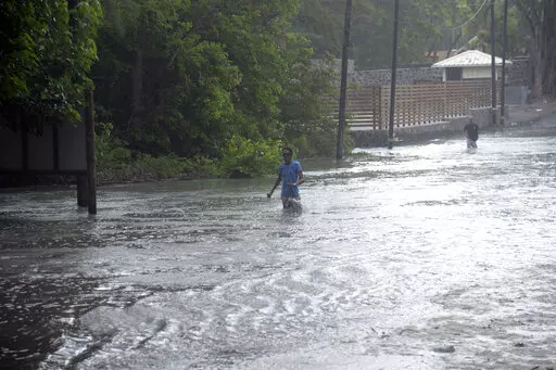 A man walks through a flooded road in the coast of the Indian Ocean Island of Mauritius Monday Feb. 20, 2023. Forecasts say Tropical Cyclone Freddy is increasing in intensity and is expected to pass north of the Indian Ocean island nation of Mauritius and make landfall in central Madagascar Tuesday evening.It's feared that up to 2.2 million people, mostly in Madagascar, will be impacted by storm surges and flooding, according to the Global Disaster Alert and Coordination System.(AP Photo/L'expre
