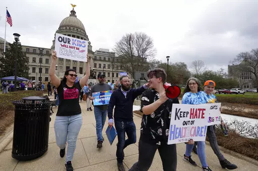 Leviathan Myers-Rowell, right, looks back at his mother Jodi Rowell, left, and calls out to her as he leads a march of transgender youth, their families and supporters from the Mississippi Capitol in Jackson, Wednesday, Feb. 15, 2023. The group staged a noon protest of House Bill 1125, which would ban gender-affirming care for trans children. (AP Photo/Rogelio V. Solis)