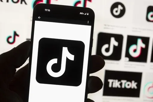 The TikTok logo is seen on a mobile phone in front of a computer screen which displays the TikTok home screen, Oct. 14, 2022, in Boston. (AP Photo/Michael Dwyer, File)