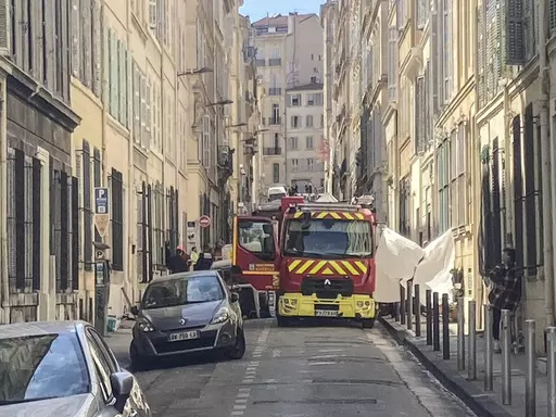 A fire truck is parked in a street near the scene where a building collapsed, in Marseille, southern France, April 10, 2023. French authorities said the death toll rose to four people after two bodies were found Monday in the rubble following an explosion that collapsed a building in the southern French city of Marseille. (AP Photo/Bishr El Touni)