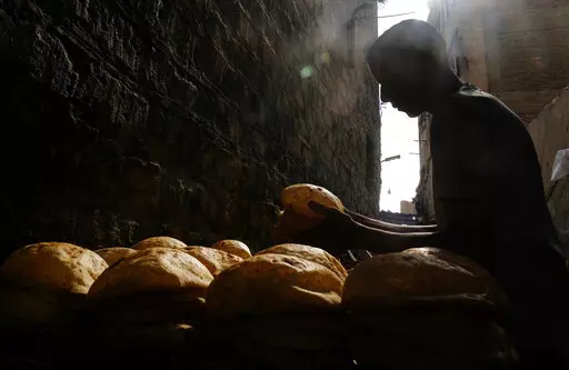 A baker stacks loaves of Egyptian traditional "baladi" flatbread outside a bakery, in the Old Cairo district of Cairo, Egypt, Sept. 8, 2022. For decades, millions of Egyptians have depended on the government to keep basic goods affordable. But a series of shocks to the global economy and Russia's invasion of Ukraine have endangered the social contract in the Middle East's most populous country, which is also the world's biggest importer of wheat. It is now grappling with double-digit inflation a