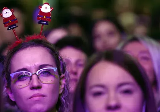 People gather for New Year's Eve, in Belgrade, Serbia, Friday, Dec. 31, 2021. New Year's Eve celebrations kicked off Friday in the Serbian capital where, unlike elsewhere in Europe, mass gatherings were allowed despite fears of the fast-spreading omicron variant of COVID-19. (AP Photo/Darko Vojinovic)
