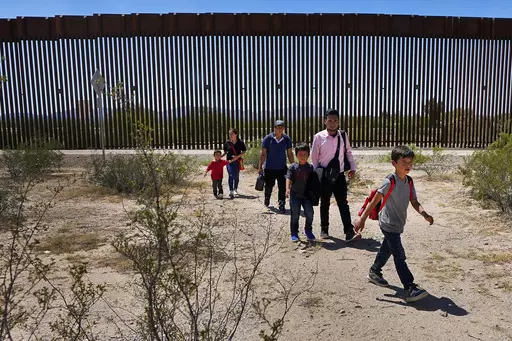 A family of five claiming to be from Guatemala and a man stating he was from Peru, in pink shirt, walk through the desert after crossing the border wall in the Tucson Sector of the U.S.-Mexico border, Tuesday, Aug. 29, 2023, in Organ Pipe Cactus National Monument near Lukeville, Ariz. U.S. Customs and Border Protection reports that the Tucson Sector is the busiest area of the border since 2008 due to smugglers abruptly steering migrants from Africa, Asia and other places through some of the Ariz
