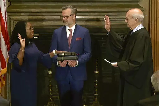 In this image from video provided by the Supreme Court, retired Supreme Court Associate Justice Stephen Breyer administers the Judicial Oath to Ketanji Brown Jackson as her husband Patrick Jackson holds the Bible at the Supreme Court in Washington, Thursday, June 30, 2022. (Supreme Court via AP)
