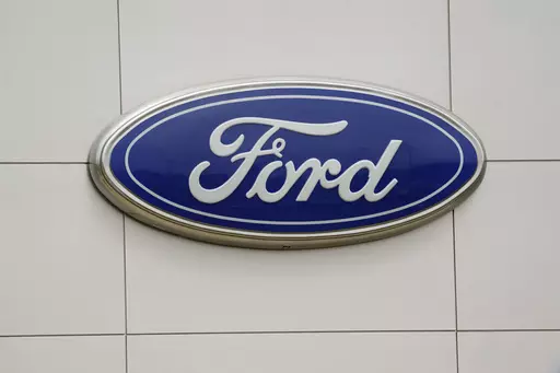 The Ford logo is seen on signage at a Ford dealership, Tuesday, July 27, 2021. The National Highway Traffic Safety Administration is investigating a Ford Motor Co. recall of more than a quarter-million Explorer SUVs in the U.S. after receiving complaints about repairs intended to prevent the vehicles from unexpectedly rolling away even while placed in “park” gear. (AP Photo/Gerry Broome, File)